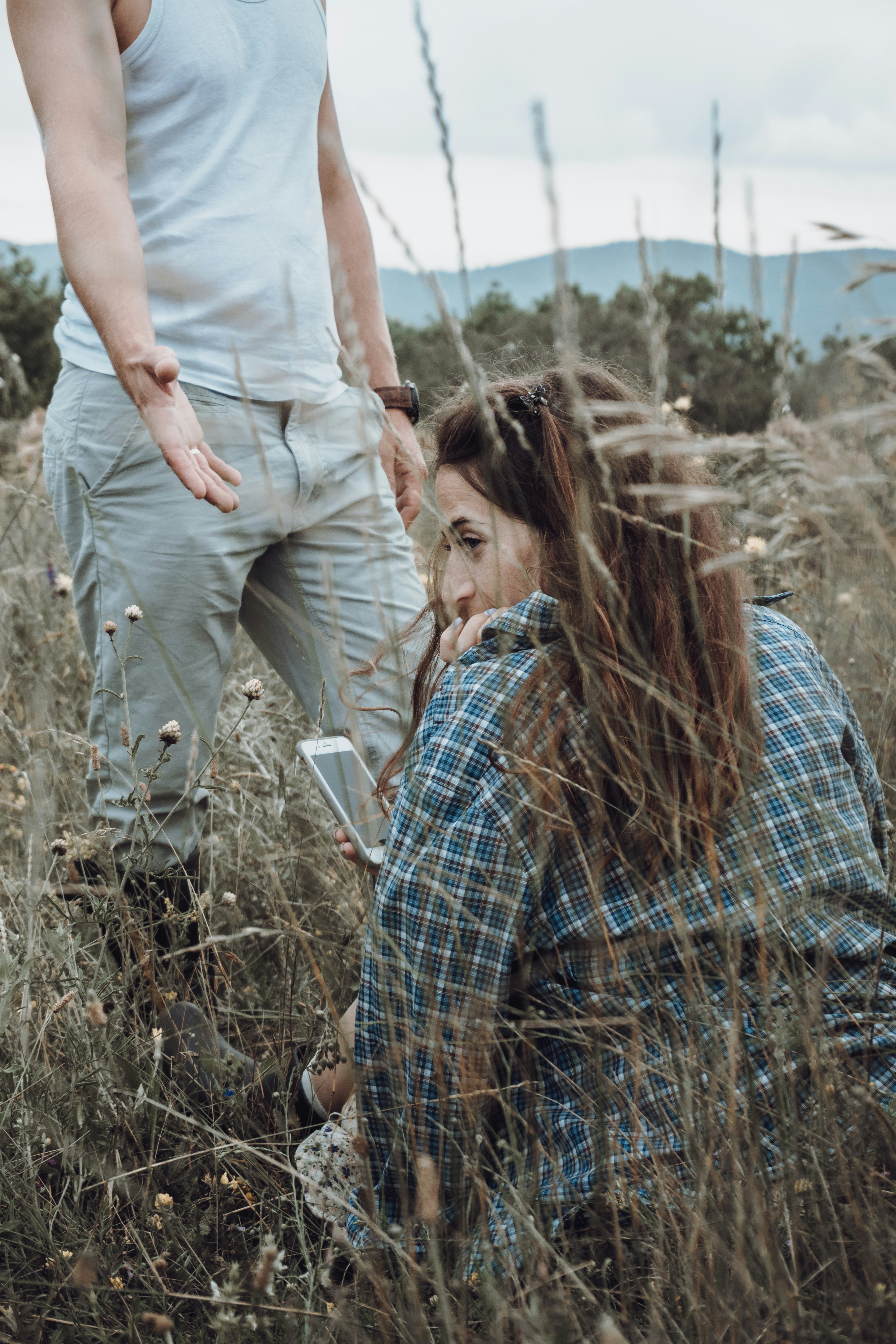 man and woman kissing on brown grass field during daytime